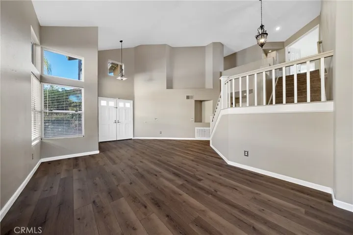 Light And Bright Living Room Featuring Newer Vinyl Flooring And High Ceilings