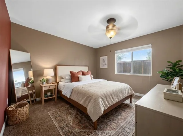 *Digitally Staged.Downstairs Bedroom With Plush Carpet And Natural Light