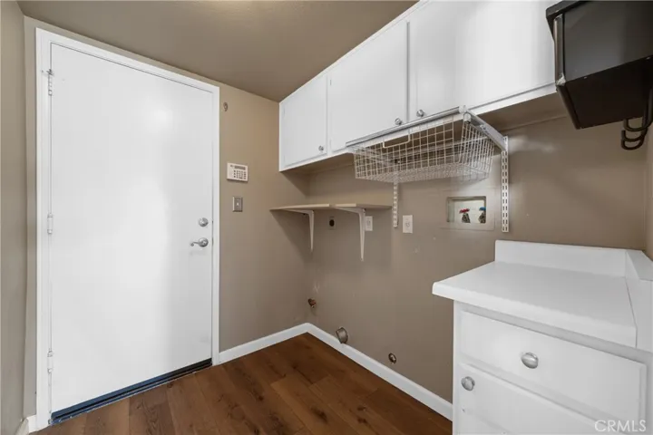 Indoor Laundry Room With Built-In Cabinetry And Storage Space