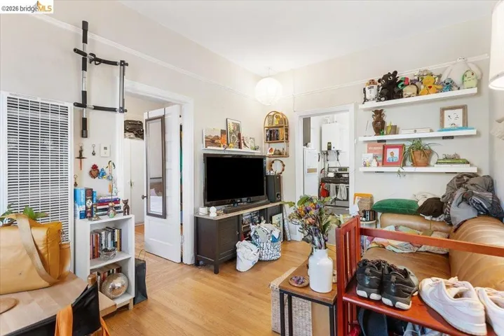 Living room with light wood finished floors, a heating unit, and tankless water heater