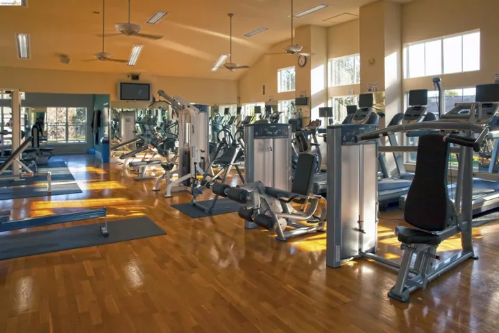 Workout area with ceiling fan and a high ceiling