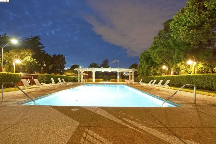 Community pool featuring a pergola and a patio