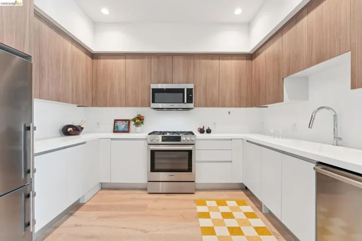 Kitchen with stainless steel appliances, light wood-style floors, modern cabinets, and recessed lighting