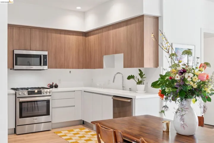Kitchen with stainless steel appliances, modern cabinets, light wood finished floors, recessed lighting, and wood finish cabinetry