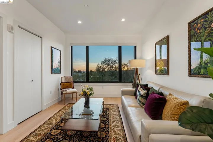 Living room with light wood-type flooring and recessed lighting