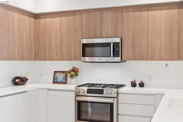 Kitchen with stainless steel appliances, modern cabinets, and light stone countertops