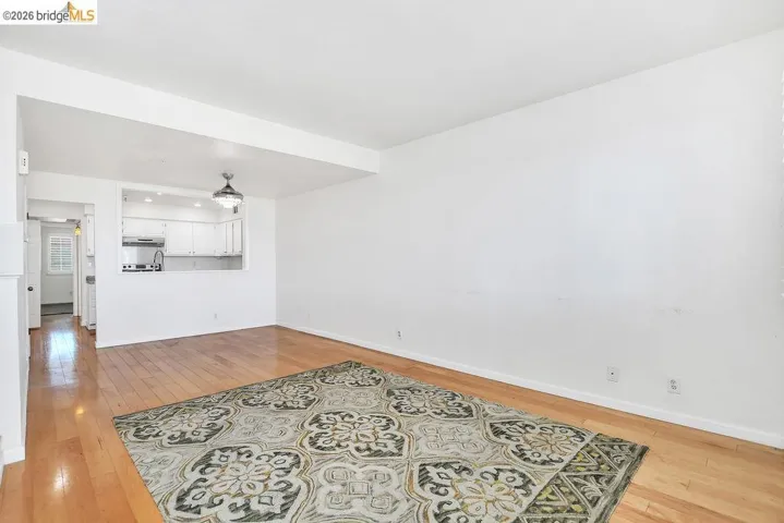 Unfurnished living room featuring light wood-style flooring and baseboards