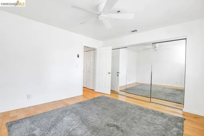 Unfurnished bedroom with light wood-style floors, a closet, and a ceiling fan