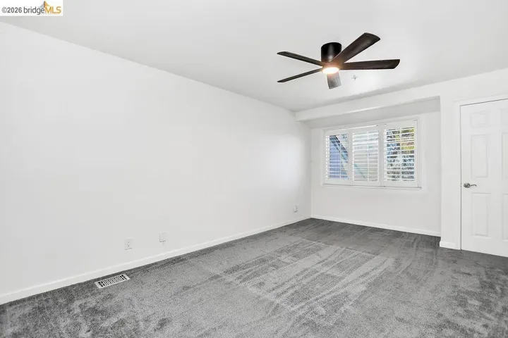 Unfurnished room with carpet floors and a ceiling fan
