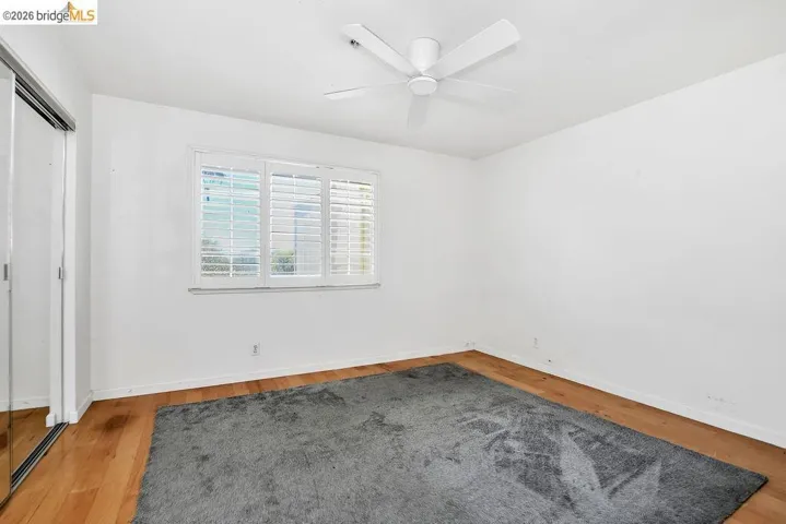 Unfurnished bedroom with a closet, wood finished floors, and a ceiling fan