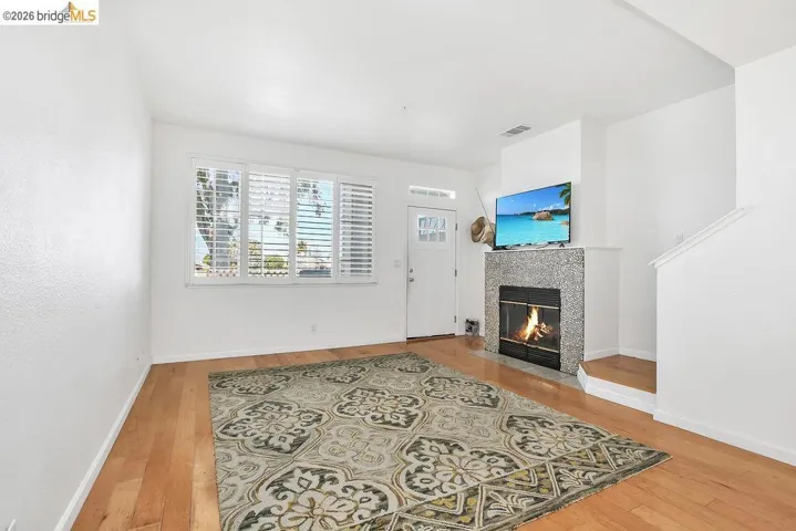 Living area featuring a tiled fireplace and light wood finished floors