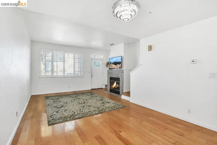 Living room featuring light wood-style floors and a tile fireplace