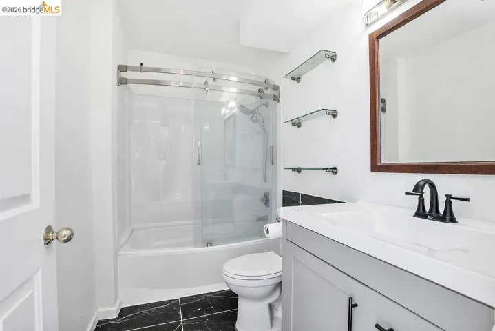 Full bathroom with vanity and combined bath / shower with glass door