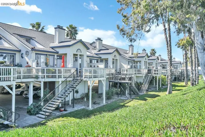 Back of house with a wooden deck, a chimney, a yard, and a shingled roof