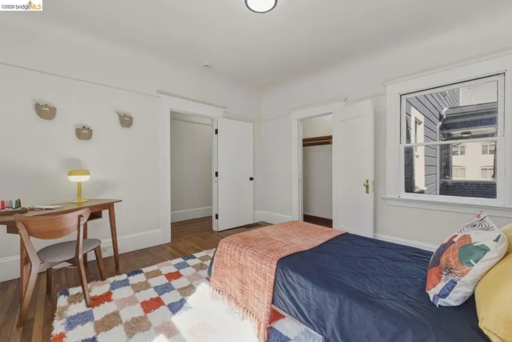 Bedroom with wood finished floors and a closet