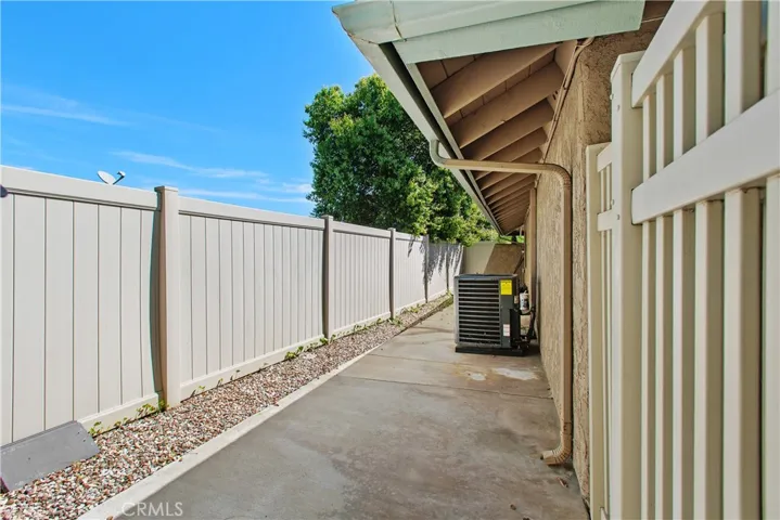 This is the other side yard. This side is fenced off from the yard and can be used as a dog run. Also, notice the new condenser for the HVAC system that was just installed in August of 2025. - including new ducting.