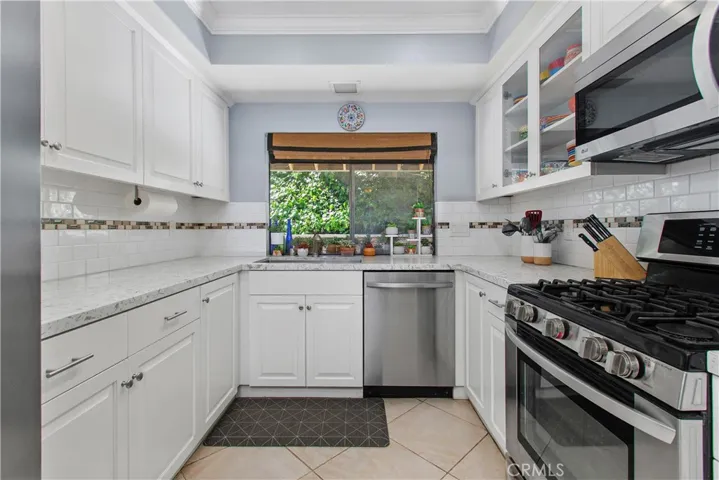 Notice the tile backsplash and updated cabinetry. The window behind the sink looks out over the side patio.
