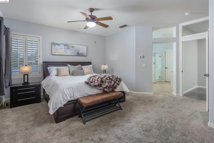 Bedroom with light carpet and a ceiling fan