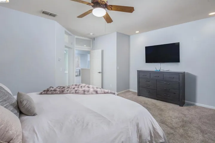 Bedroom with light carpet, a ceiling fan, and recessed lighting