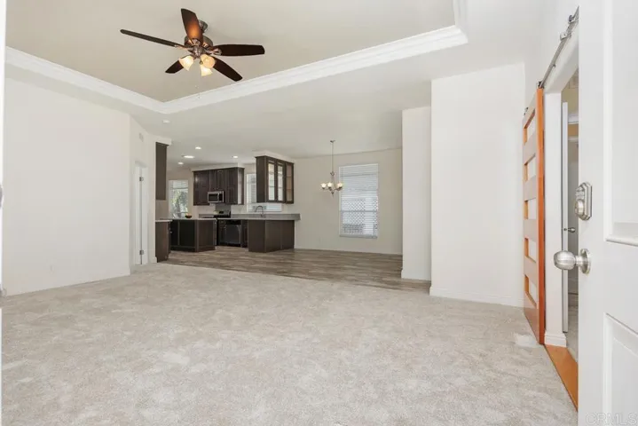 Looking towards the kitchen .Note:ceiling fan and tray ceiling