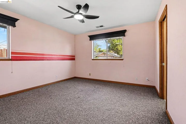 Spare room with light carpet and a ceiling fan