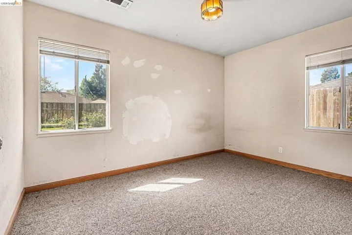 Unfurnished room featuring plenty of natural light