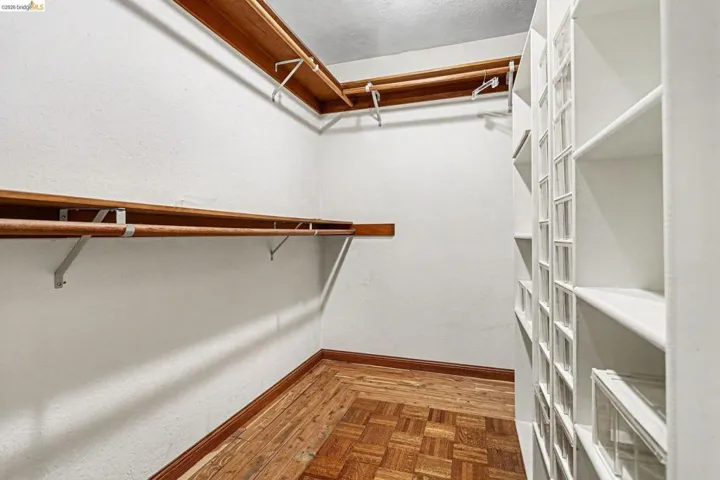 Walk in closet with parquet flooring