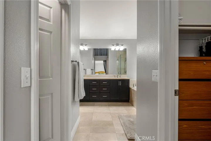 Looking into the primary bath from the bedroom. There are two walk in closets, one on each side