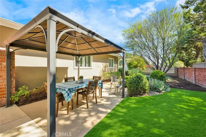 A gazebo covers the dining area with wood table and chair/bench included.