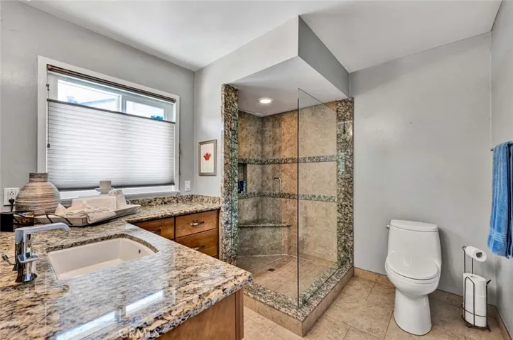 Primary bath has step in shower and granite countertops.