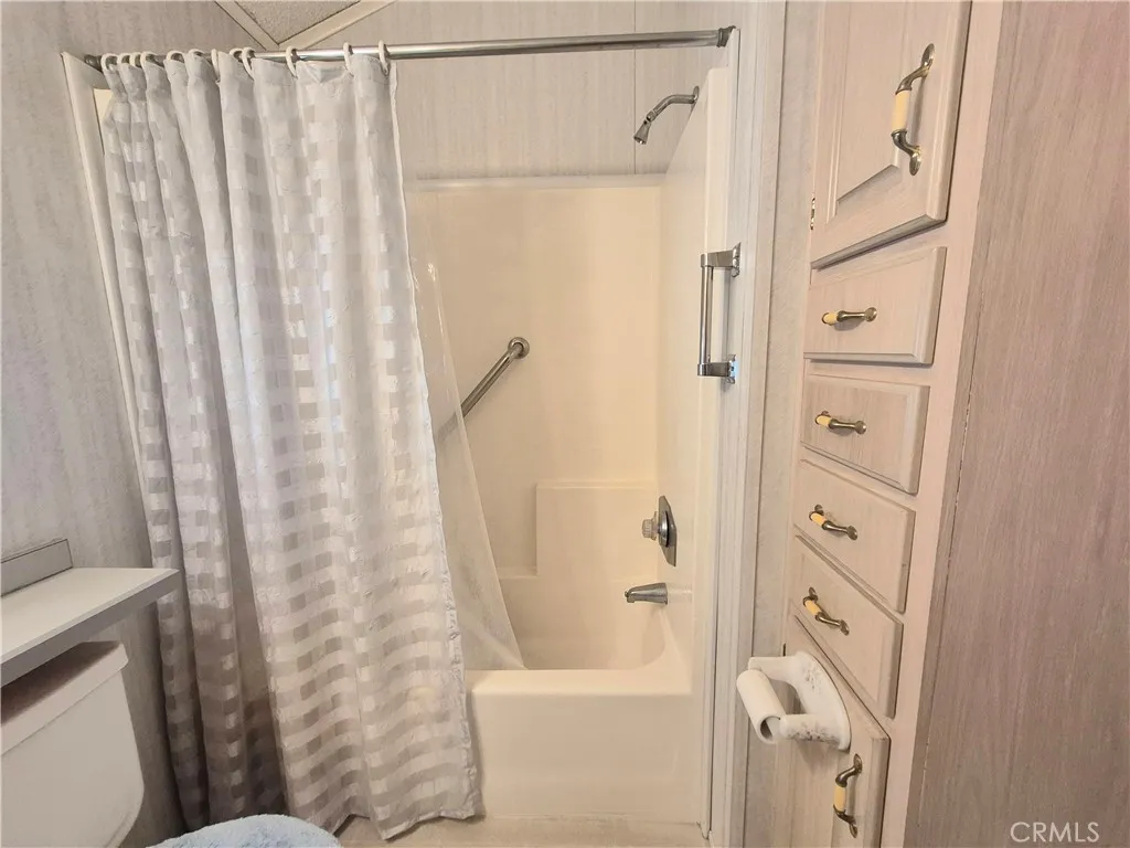 Tub with grab bars and lots of light cabinettry