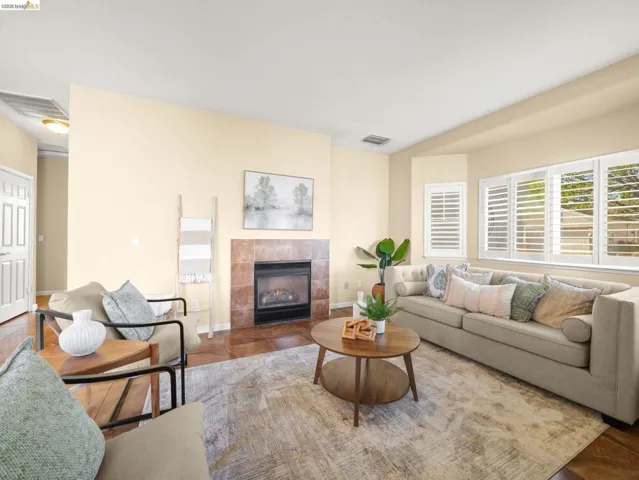 Tiled living room featuring a tiled fireplace and baseboards