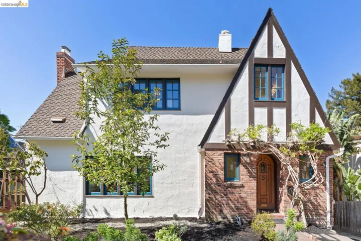 View of front facade with a chimney, stucco siding, and brick siding