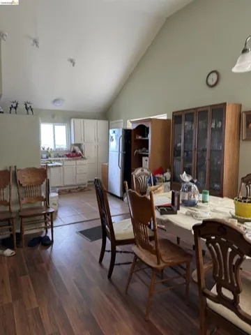 Dining space featuring vaulted ceiling and dark wood-type flooring