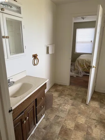 Bathroom featuring vanity, stone finish flooring, and connected bathroom