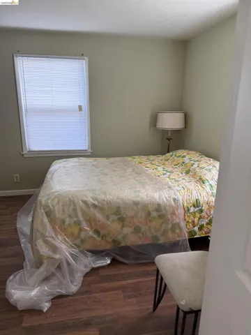 Bedroom with dark wood-style flooring