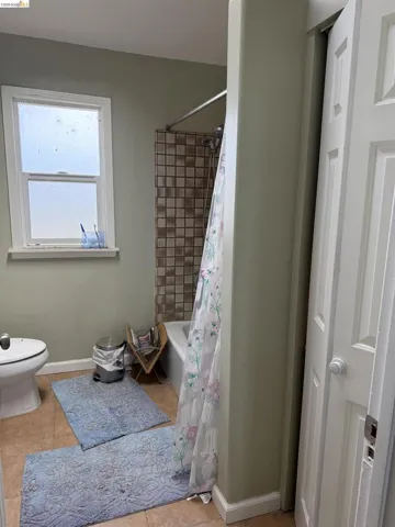 Full bath featuring baseboards and shower / bath combo