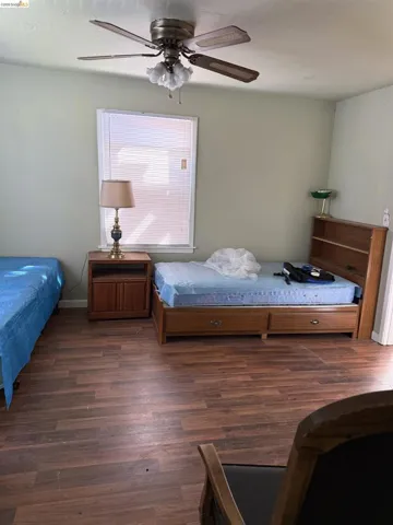 Bedroom with dark wood-style flooring and ceiling fan