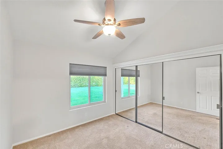 Guest bedroom with cathedral ceilings and view of greenbeltt