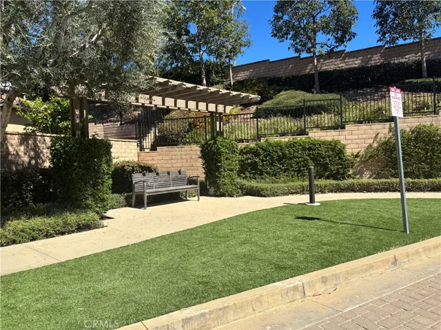 Located at a cul-de-sac with green belt and a bench under a patio cover.