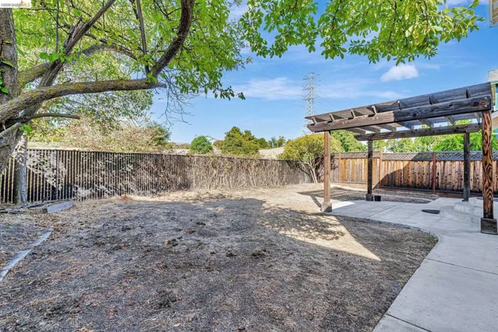 Fenced backyard featuring a pergola and a patio area