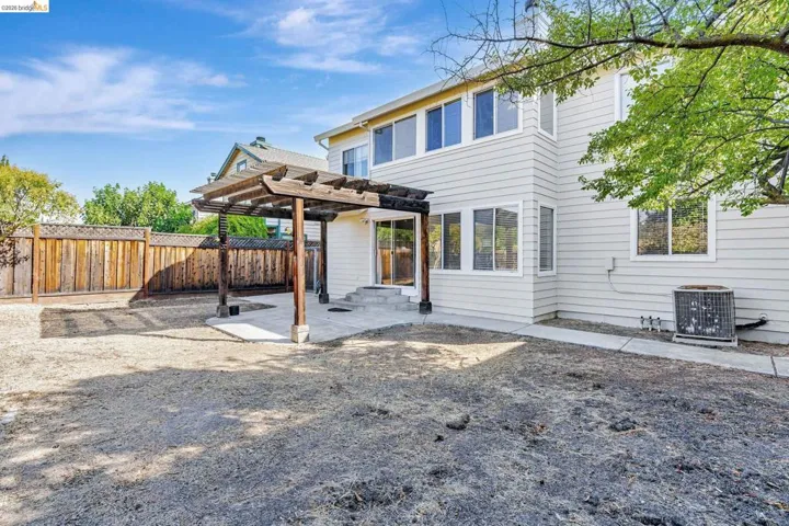 Rear view of house featuring a pergola, a patio area, and a fenced backyard