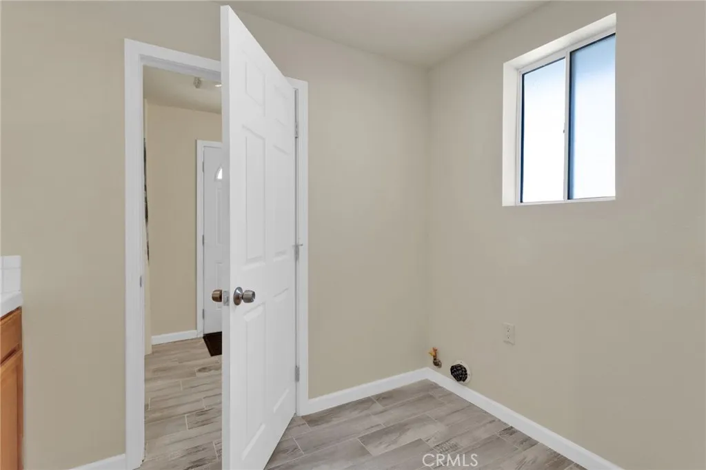 Dedicated laundry area with ample space for full-size appliances and additional storage, designed for everyday convenience
