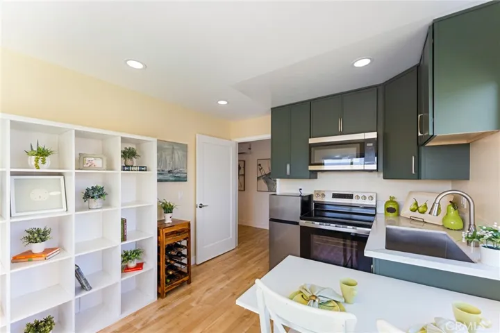 ADU Kitchen, Dining Area, Bedroom Area with Recessed Lighting, Custom Cabinetry, Sink, Range, Refrigerator, Microwave