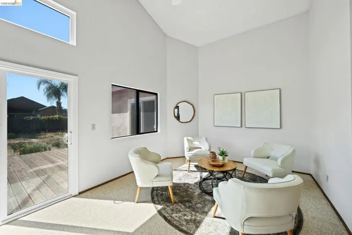 Sitting room with a high ceiling, carpet, and plenty of natural light
