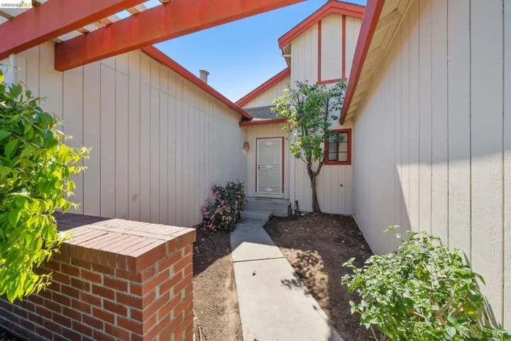 View of exterior entry featuring a shingled roof