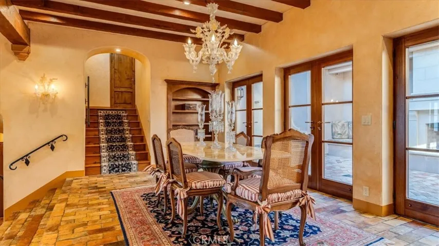 Glass doors lead to the inner courtyard. The glass chandelier and light sconces are imported from Murano Italy.