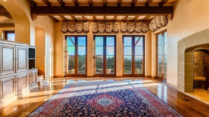 Living Room. The wood floors are solid bleached walnut, hand milled and hand scraped. Glass doors lead to front ocean view patio. The Roman Blinds are electric for ease of use.