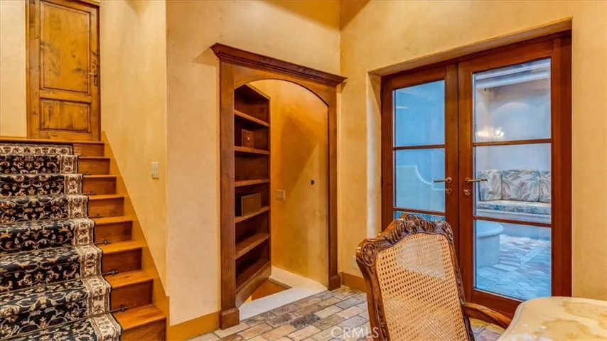 The cupboard next to the stairs is a hidden door to the wine cellar room.