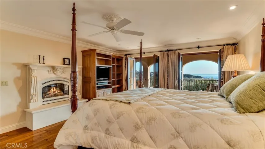 Primary Bedroom is beholden with a stone fireplace, white water ocean views and covered stone patio with ocean views.
